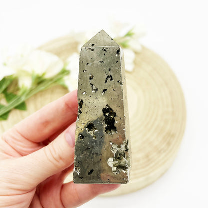 polished crystal obelisk with pyrite stone